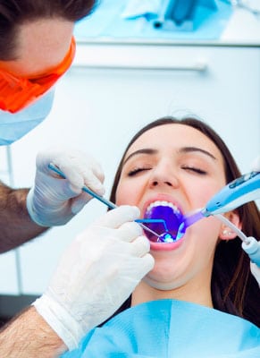 Un dentista practica un empaste a una paciente.